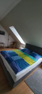 a bed with a colorful comforter in a room at Ferienwohnung Salzwedel in Salzwedel