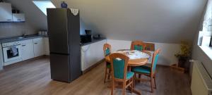 a kitchen with a table and chairs and a refrigerator at Ferienwohnung Salzwedel in Salzwedel +7 photos