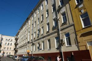 un gran edificio en una calle de la ciudad con gente pasando por delante en Napoleon Hostel Moscow, en Moscú