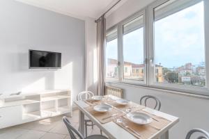 a dining room with a table and chairs and windows at Excelsior in Piombino