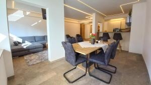 a dining room and living room with a table and chairs at Luxus Terrassenappartement Berg & See 1 in Bodensdorf