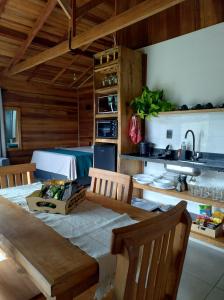 a dining room with a table and a kitchen at Chalé Céu Estrelado in Paraisópolis