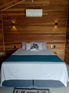 a bedroom with a large bed with wooden walls at Chalé Céu Estrelado in Paraisópolis