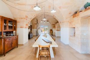 a dining room with a table and a stone wall at Masseria Lovetere Rooms - Salento Selection in Copertino