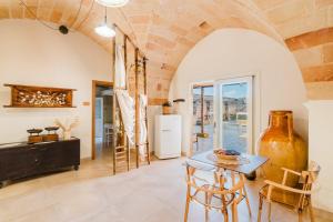 a dining room with a table and chairs and a brick wall at Masseria Lovetere Rooms - Salento Selection in Copertino