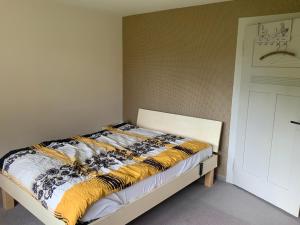 a bed in a room next to a white door at Appenzellerland Schöne Wohnung in einem Wandergebiet in Teufen