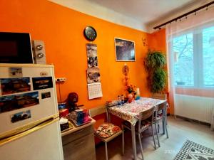 a dining room with a table and a refrigerator at Karancs Apartman Salgótarján in Salgótarján