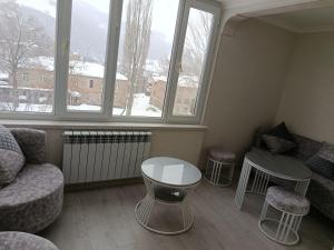 a living room with a couch and a table and windows at Jermuk Calm House in Jermuk