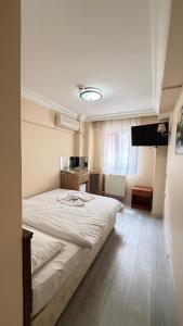 a bedroom with a large white bed and a television at otel efendi in Istanbul