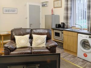 a living room with a leather couch in a kitchen at Bankfield - Uk5660 in Aberdeen
