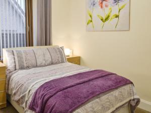 a bedroom with a bed with a purple blanket on it at Bankfield - Uk5660 in Aberdeen +3 photos