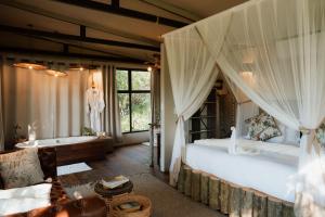 a bedroom with a canopy bed and a tub at Maroelani Lodge- Greater Kruger Private Reserve in Hoedspruit +94 photos