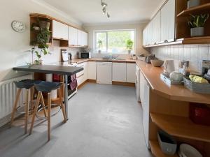 a kitchen with white cabinets and a black counter top at Lavender Cottage in Louth