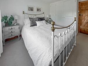 a bedroom with a white bed with a white comforter at Lavender Cottage in Louth +8 photos