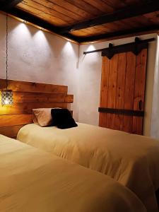 a bedroom with two beds and a wooden wall at Casa de Campo Huasca - Centro in Huasca de Ocampo