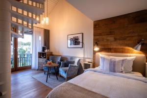 ein Schlafzimmer mit einem Bett, einem Stuhl und einem Tisch in der Unterkunft LILIENBERG in Ermatingen + 58 Fotos
