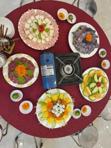 a table with many plates of food on it at Chely Hotel in Mù Cang Chải