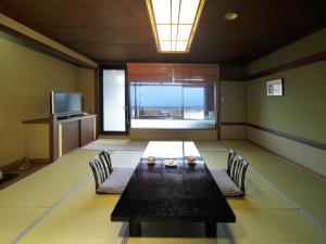 a room with a table and chairs and a large window at かね吉一燈庵 in Mitaka
