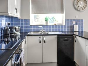 a kitchen with a sink and a window at The Lookout in Pendine