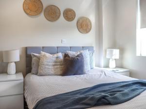 a bedroom with a bed with blue sheets and pillows at The Lookout in Pendine