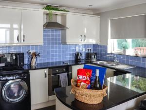 a kitchen with a counter top with a basket of food at The Lookout in Pendine