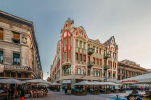 an orange building with tables and umbrellas in front of it at OLD TOWN Palatul Agoston Galgon in Timişoara