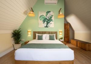 a bedroom with a large bed with green walls at Jalvasa Villa's in Canacona