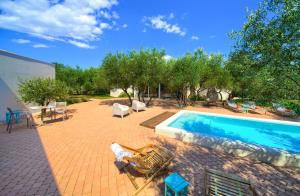 a backyard with a swimming pool and chairs and trees at Margari Villas in Linardići