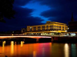 a bridge over a river in front of a building at 206 By The Bridge Apartment in Inverness