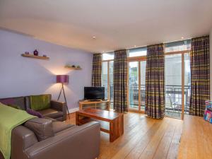 a living room with a couch and a tv at 206 By The Bridge Apartment in Inverness