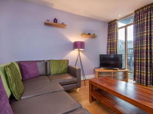 a living room with a couch and a tv at 206 By The Bridge Apartment in Inverness