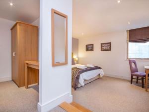 a bedroom with a bed and a desk and a mirror at 206 By The Bridge Apartment in Inverness +4 photos