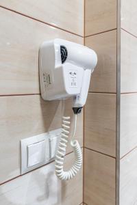 a phone hanging on a wall with a handset at Pensjonat Perła Pienin in Grywałd +19 photos