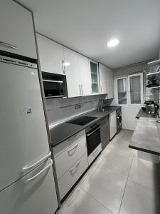 a kitchen with stainless steel appliances and white cabinets at Living Canovas in Alcalá de Henares