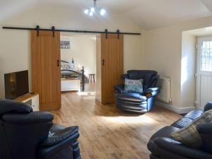 a living room with two chairs and a television at Penrhos Bach in Llanerchymedd
