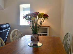 a vase of flowers sitting on a table at Penrhos Bach in Llanerchymedd
