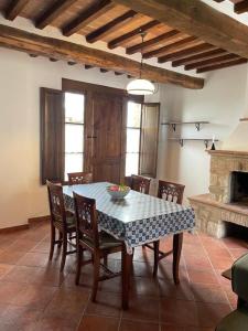 ein Esszimmer mit Tisch und Stühlen sowie einem Kamin in der Unterkunft Borgo Beccanella in Asciano
