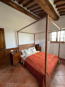 ein Schlafzimmer mit einem Himmelbett mit einer roten Decke in der Unterkunft Borgo Beccanella in Asciano + 73 Fotos