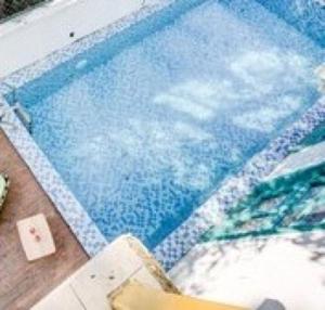 a swimming pool with a reflection of the sky at Hotel O Benaulim Beach Goa in Goa