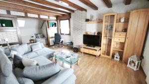 a living room with a couch and a tv at Gästewohnung Urfttalsperre in Schleiden