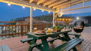 a picnic table on a deck with a grill at Ganghwa Daeun pension in Incheon