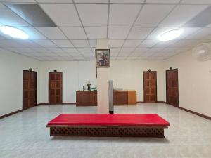 a large room with a red table in the middle at Toon Guesthouse Sukhothai in Sukhothai