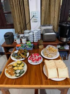 a wooden table with plates of food on it at Toon Guesthouse Sukhothai in Sukhothai