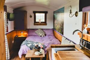 a small bedroom with a purple bed and a sink at Finest Retreats - Weardale Shepherds Hut in Bishop Auckland