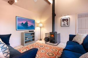 a living room with a blue couch and a fireplace at 3 Bed in Ringsfield oc-m33329 in Wingfield