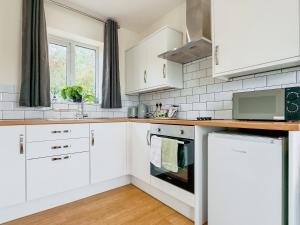 a white kitchen with white cabinets and a window at Deer Lodge - Ukc4325 in Pidley