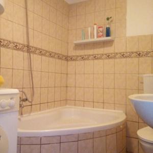 a bathroom with a bath tub and a sink at InterSoul Apartman in Gyöngyös