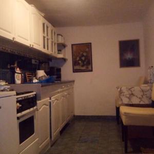a kitchen with white cabinets and a stove top oven at InterSoul Apartman in Gyöngyös