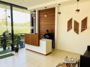 a man sitting at a desk in a lobby at Homey - vythiri bus station in Vythiri