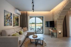 a living room with a couch and a tv at Golden Silence in Platanias +37 photos
